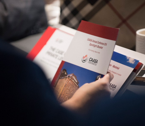 A hand holding CAASA brochures